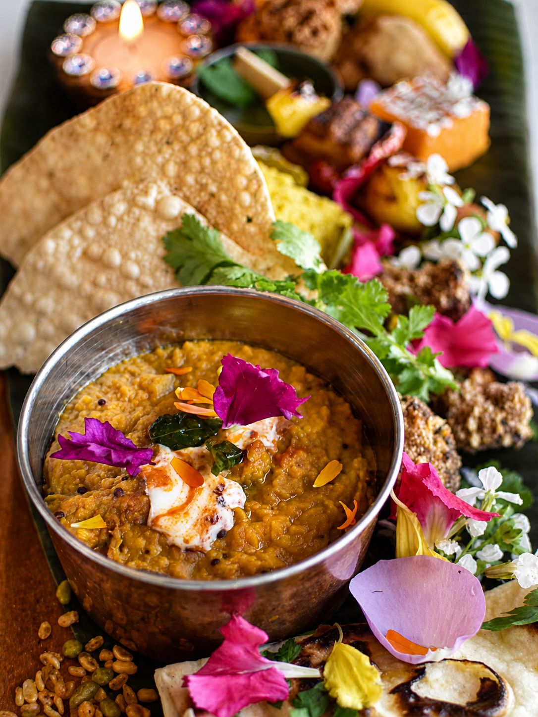 A colourful vegetarian curry with flatbread and edible flowers